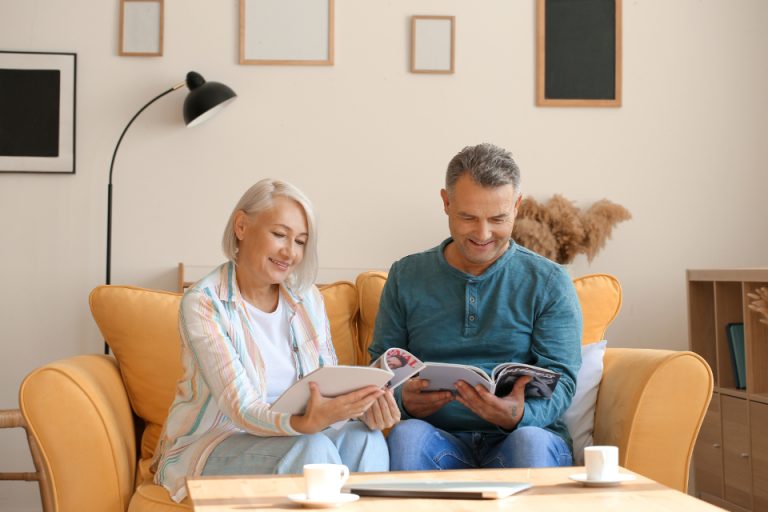 Two people sitting and reading together in a bright living room