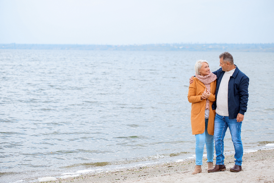 Two people walking together outdoors by the water