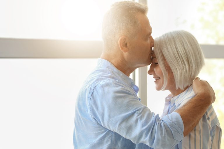 An older couple sitting together in daylight at home
